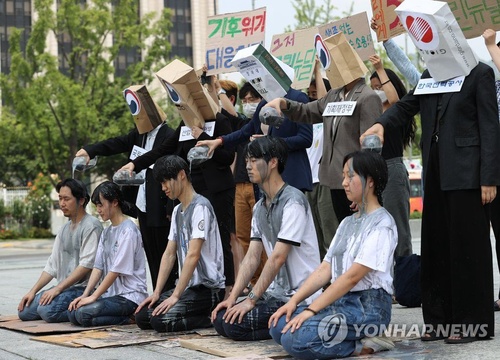 韩国青年跪地上演“灰汁淋头” 呼吁加强气候保护【组图】 第1页